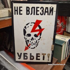 Aluminiowa tabliczka z rosyjskim napisem ostrzegawczym Nie wchodź bo zginiesz na ciemnym tle