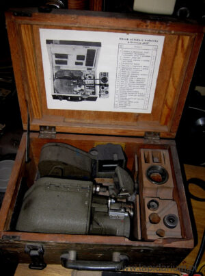 Czechosłowacki aparat fotograficzny samolotowy z lat 60. XX wieku, relikt zimnej wojny na tle neutralnym.