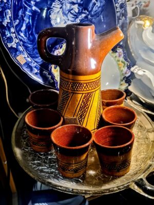 Ceramiczny komplet do miodów z Polski z XX wieku, składający się z naczynia z przykrywką i łyżeczki.