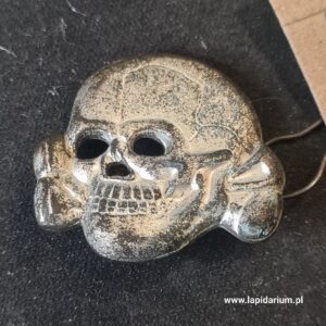 Oryginalna metalowa czaszka Totenkopf z czapki SS, sygnowana M1/52 na rewersie, przedmiot kolekcjonerski