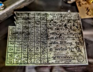 Srebrna broszka z Getta Łódzkiego z reliefem przedstawiającym kartkę żywnościową, ok. 1941 rok.