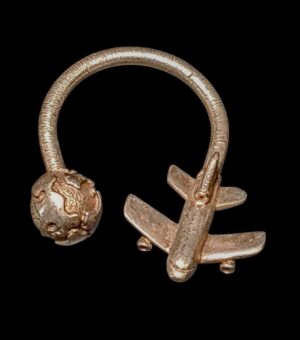 Srebrny brelok o tematyce lotniczej firmy Tiffany and Co. New York z widoczną puncą na ciemnym tle.