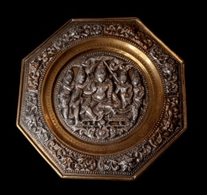 Antyczny talerz dekoracyjny z Tajlandii z XIX wieku z misterną inkrustacją srebrem na ciemnym tle.