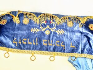 XIX-wieczny żydowski baldachim do parachetu z ciemnego aksamitu, bogato haftowany srebrnymi i złotymi nićmi z motywami koron i gwiazd.