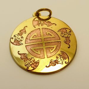 Srebrny chiński amulet z pięcioma nietoperzami otaczającymi centralny znak, symbolizujący pięć błogosławieństw.