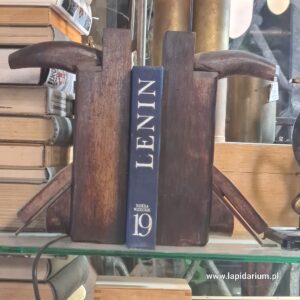 Dwa stare drewniane heble używane jako solidne, industrialne podpórki do książek na półce.