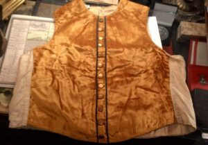 Zabytkowa czarna kamizelka masońska z początku XX wieku, widok z przodu, element stroju rytualnego z Anglii.