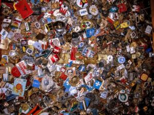 Kolekcja różnych odznak i przypinek kolekcjonerskich z całego świata na tle mapy.