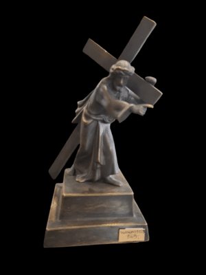 Mosiężna figurka Jezusa niosącego krzyż na tle starej ceglanej ściany - varsaviana z Warszawy