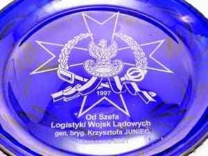 Niebieska szklana patera ozdobna z grawerunkiem orła wojskowego i krzyża maltańskiego, pamiątka od gen. K. Juniec 2001