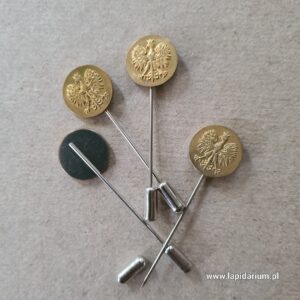 Mosiężna wpinka patriotyczna z wizerunkiem Orła Białego w koronie na szpilce, widok z przodu.