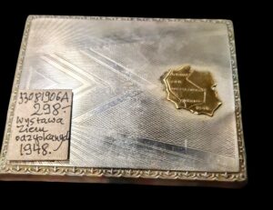 Papierośnica z alpaki z mosiężną plakietką przedstawiającą mapę Polski, pamiątka z Wystawy Ziem Odzyskanych 1948 we Wrocławiu.