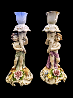 Para białych porcelanowych świeczników z XIX wieku z Włoch, ozdobionych motywem putto (dziecięcych aniołków).