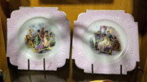 Para białych talerzy porcelanowych z rosyjskiej fabryki Gardnera, zdobiona złoconym szlaczkiem, widok z góry.