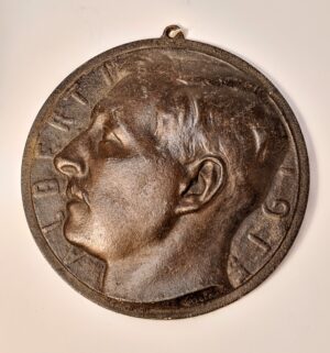 Zabytkowy, patynowany medal z brązu z profilem króla Belgów Alberta I, widocznym napisem ALBERT i uszkiem.