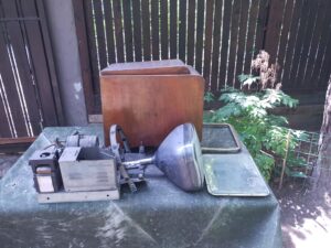 Zdemontowany zestaw pierwszego polskiego telewizora Wisła z lat 50. XX wieku z lampą kineskopową, drewnianą obudową i podzespołami.