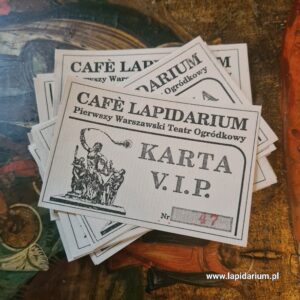 Oryginalne karty wstępu V.I.P. do Cafè Lapidarium, warszawskiego teatru ogródkowego z lat 90. na tle antyków.